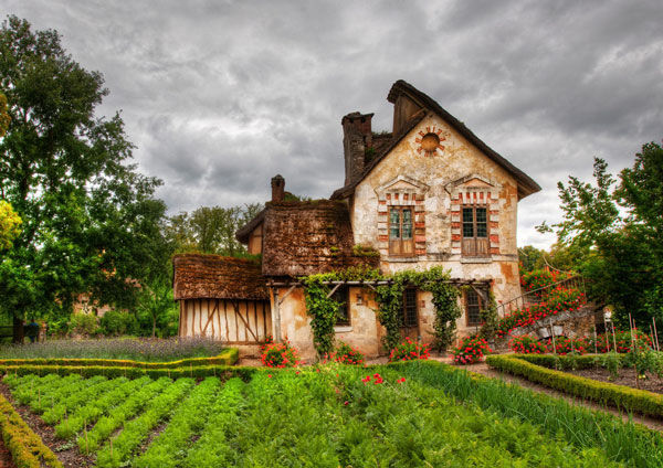 Ngôi nhà đầy rau xanh, hoa và cây là ở Hameau de la Reine ở Versailles
