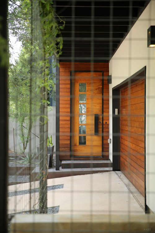 Cánh cửa với chất liệu gỗ và thép kết hợp, bên cạnh đó còn được lắp đặt  ​thêm cả hệ thống khóa công nghệ, lối vào được bố trí ngay bên cạnh nhà để xe
