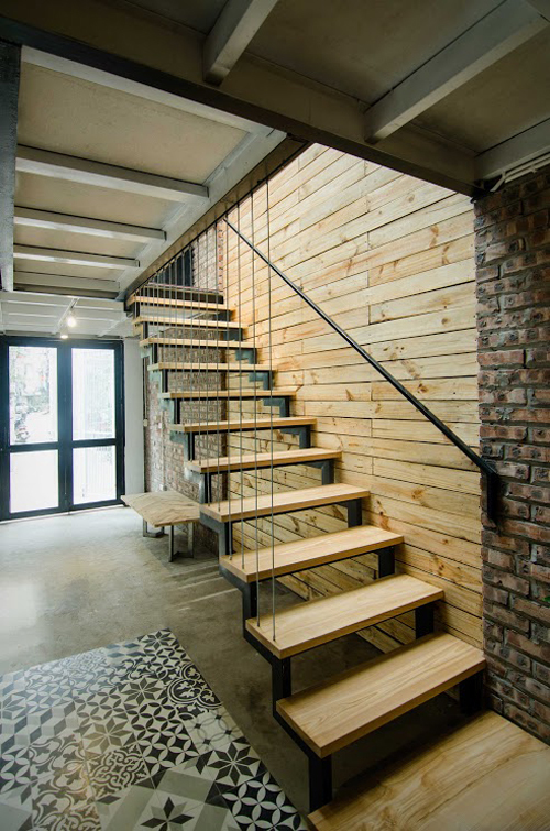 Cầu thang là sự kết hợp giữa sắt hộp và gỗ tự nhiên, với sự tiết chế về  chi tiết tạo sự nhẹ nhàng, không rườm rà cho kiến trúc tổng thể