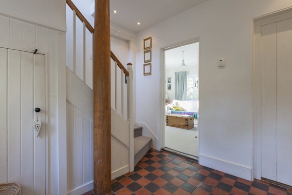 Sàn gạch dẫn lối vào không gian phòng khách, phòng bếp  ​và cầu thang nhỏ dẫn lên tầng 2