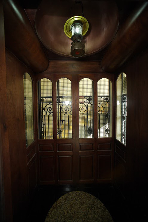 Khoang thang máy bằng gỗ, nằm trong khung sắt được chạm trổ họa tiết,  ​người sử dụng có thể điều khiển bằng bảng nút hiện đại