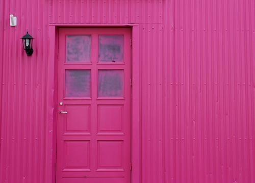 Cả cánh cửa lẫn bức tường bên ngoài được sơn màu hồng nổi bật ​ tại Reykjavik, Iceland