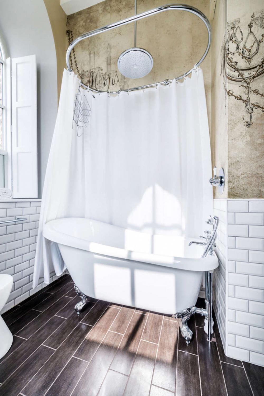 Rèm che bồn tắm và trang trí tường nhấn mạnh đặc điểm của một  ​ngôi nhà đồng quê theo một cách rất tinh tế và phong cách