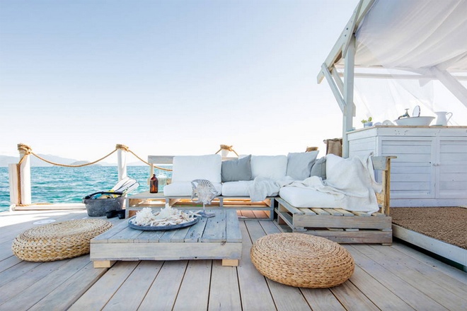 Phòng khách ngoài trời với bộ bàn ghế bằng gỗ, kết nối tối đa ​ với biển bao la xung quanh