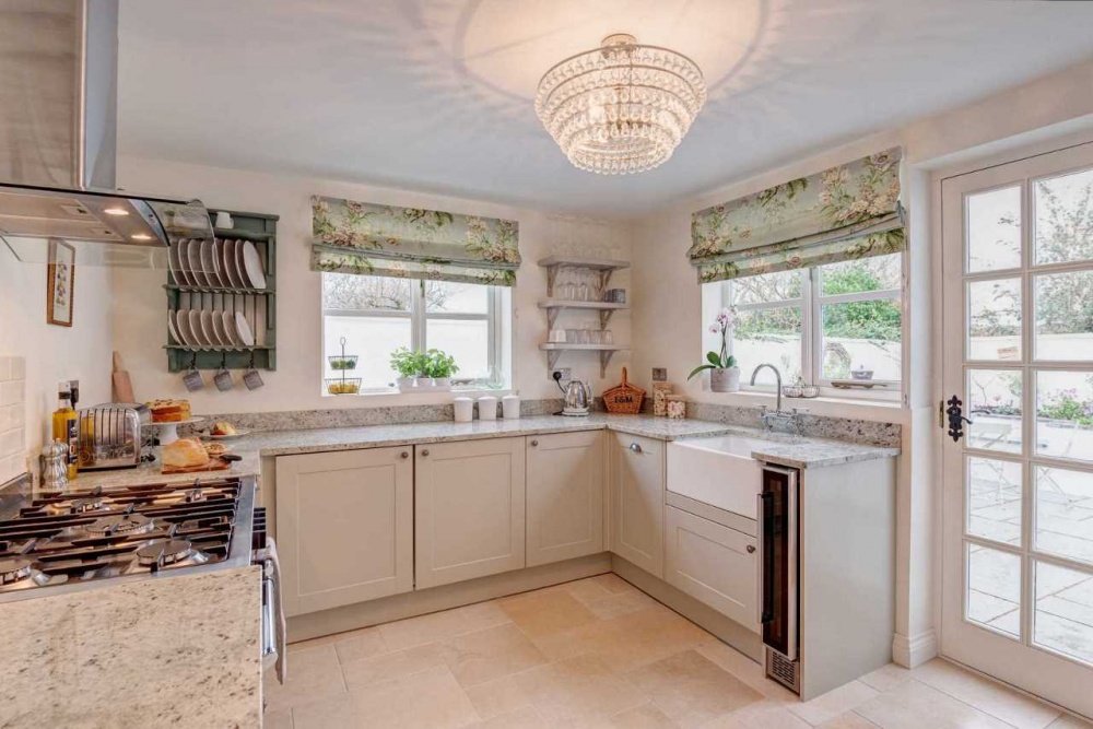 Phòng bếp tiện nghi với sự kết hợp thêm cửa kính và rèm cửa màu xanh họa tiết  ​hoa vintage càng khiến cho phòng bếp trở nên tinh tế và nhẹ nhàng