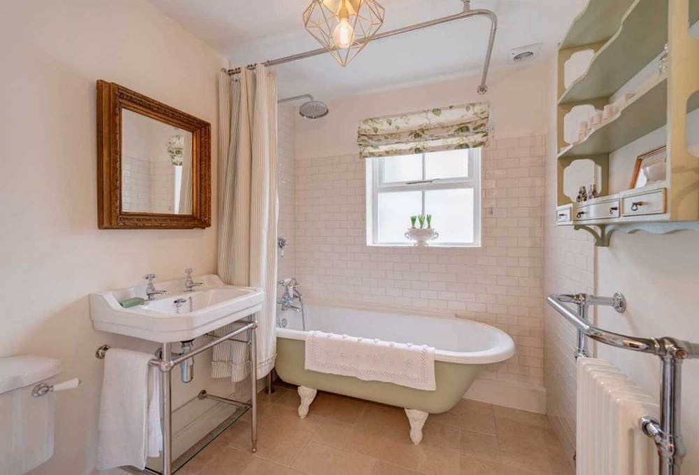 Phòng tắm với chiếc đèn cổ ấm áp, màu xanh pastel nhẹ nhàng  ​kết hợp cùng màu trắng tạo góc không gian vintage đúng điệu