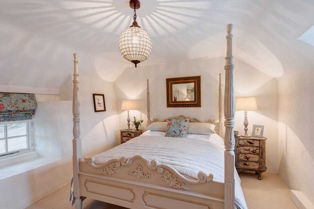 Trong phòng ngủ, một chiếc giường phong cách colonial cỡ lớn với những chiếc tủ gỗ  đầu giường bên cạnh, các bức tường đều được sơn màu trắng  ​để căn phòng trông sáng sủa và rộng rãi