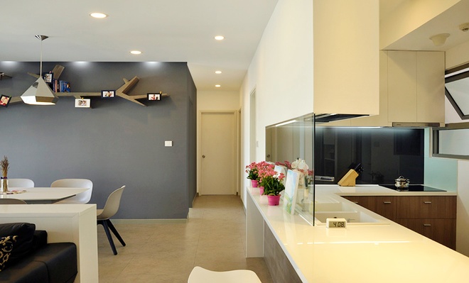 Thiết kế bếp và quầy bar tinh giản với sự tương phản giữa  ​hệ tủ kệ màu trắng sáng với vách kính ốp tường tối màu