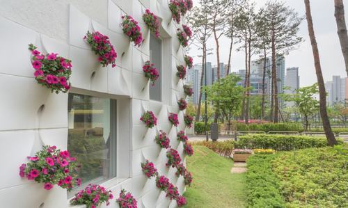 Các bức tường đá vôi được tô điểm bởi các khung cửa sổ vuông vớinhiều kích thước khác nhau và 230 chậu hoa được trang trí bên trong giúp ​ kết nối thiên nhiên sống động ở mỗi cấp độ
