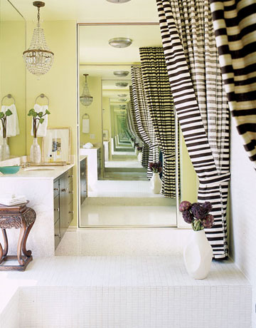 Phòng tắm đầy màu sắc với rèm cửa sọc, không gian được mở rộng nhờ tấm gương lớn