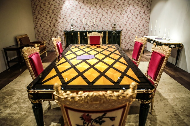 Bộ bàn ghế được làm từ gỗ sồi đánh bóng sơn mài, chất liệu nhung đỏ cùng các họa tiết hoa hồng thêu tay, giá chiếc bàn có giá hơn 600 triệu, mỗi chiếc ghế đơn 147 triệu