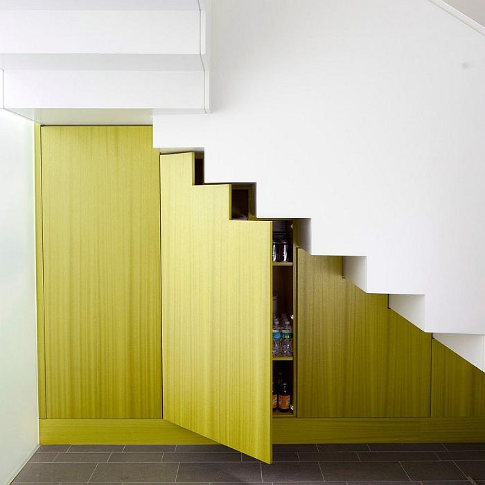 Không gian lưu trữ sắc màu nổi bật trên nền cầu thang và tường trắng tinh khiết gây ấn tượng mạnh về mặt thị giác.