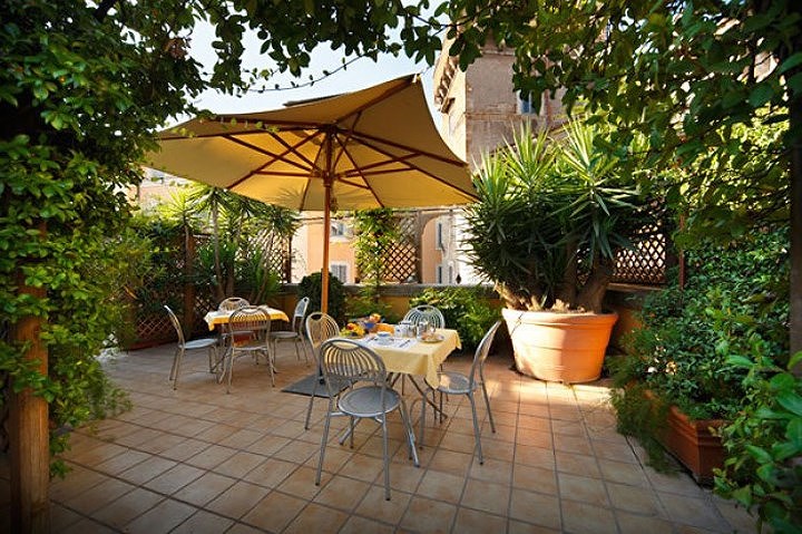 Vào mùa hè, chủ nhân sử dụng thêm một ô che lớn giữa khoảng sân tạo cảm giác mát mẻ cho vườn trên sân thượng.