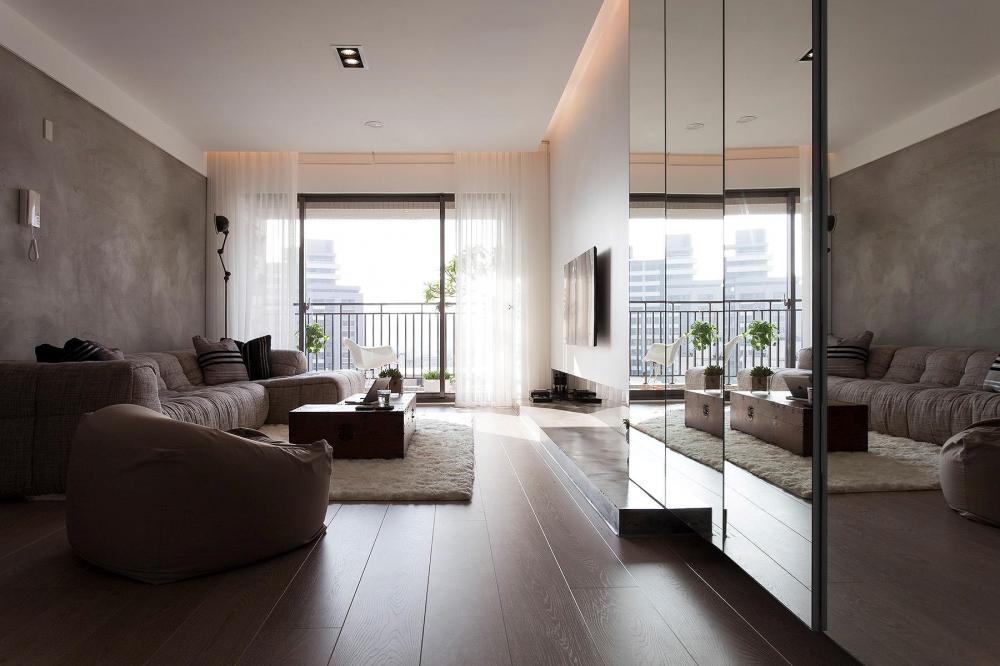 Tại phòng khách căn hộ hiện đại, bức tường bê tông thô trở thành phông nền cho nội thất nổi bật hơn.