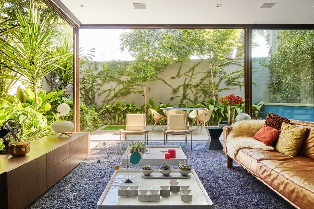 Trong nhà 2 tầng, ghế sofa được bố trí đối diện với vườn cây bên ngoài tạo cảm giác gần gũi với thiên nhiên hơn. phòng khách nhà 2 tầng