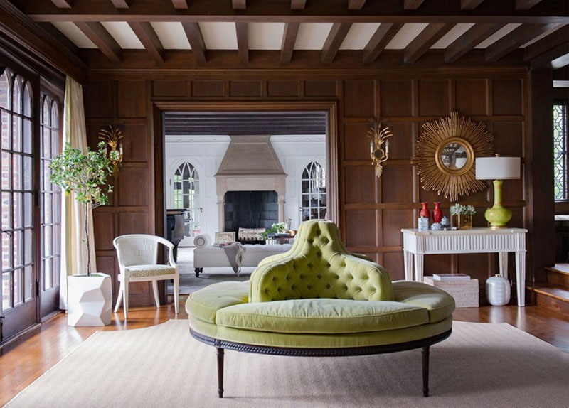 Hình ảnh ghế sofa nhung màu xanh lá đặt trong căn phòng sử dụng chất liệu gỗ chủ đạo