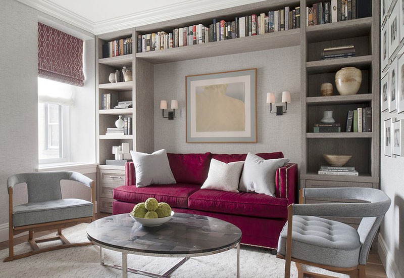 Hình ảnh phòng khách mùa đông với sofa nhung hồng tím, giá sách cao lịch trần, cửa sổ kính