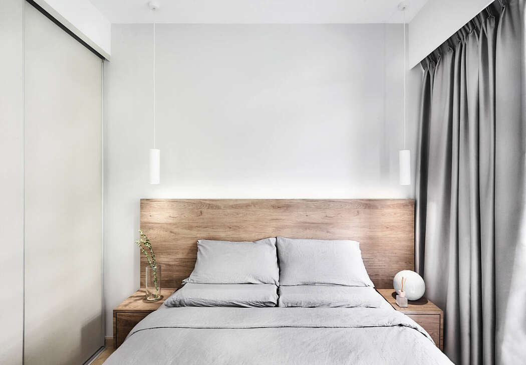 Hình ảnh phòng ngủ màu trắng xám chủ đạo, đầu giường ốp gỗ, đèn trang trí dạng thả