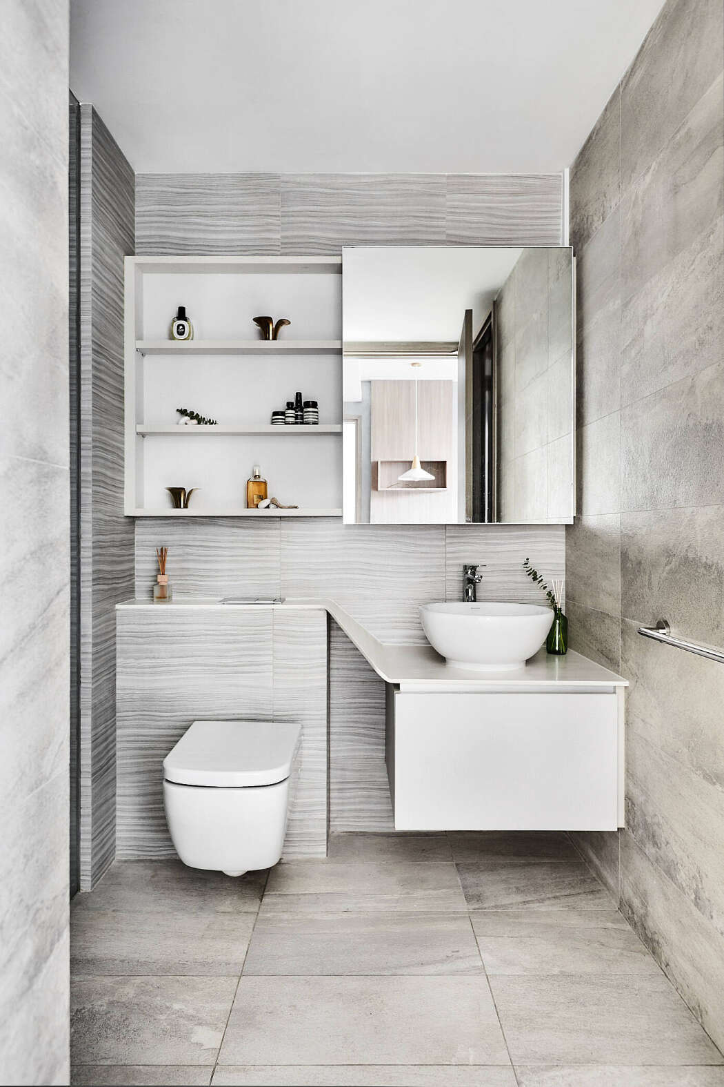 Hình ảnh phòng vệ sinh hiện đại với gương lớn, kê mở gắn tường, đá ốp