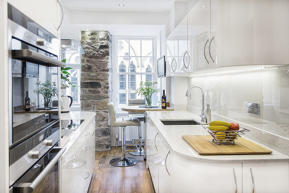 Hình ảnh phòng bếp nhỏ ấn tượng với tường đá thô mộc, bàn ăn sáng nhỏ xinh, tủ kệ lưu trữ thoải mái
