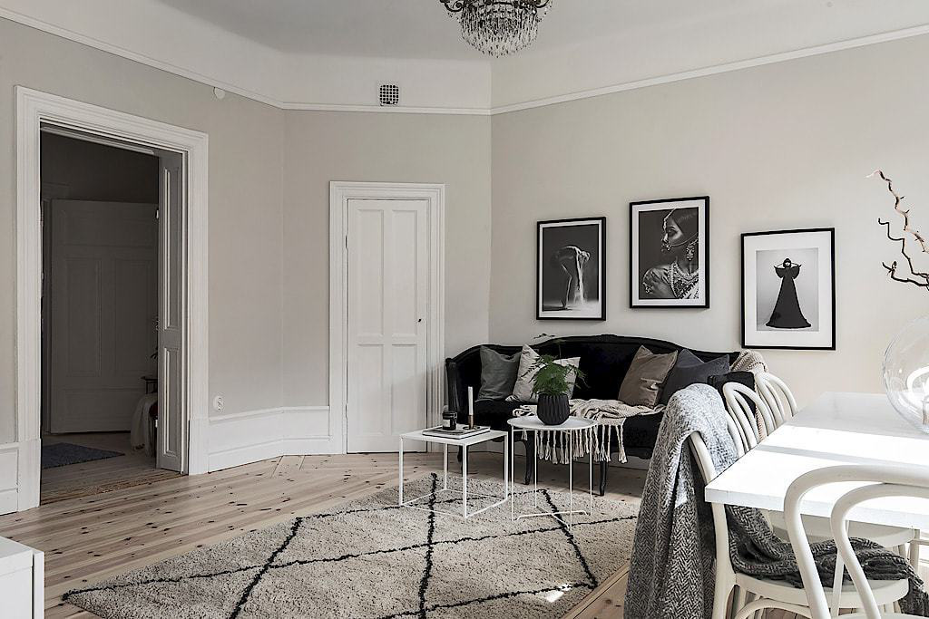 Hình ảnh bộ ba tranh treo tường đen - trắng phía sau ghế sofa tạo điểm nhấn hút mắt và hài hòa với tổng thể căn hộ 62m2.
