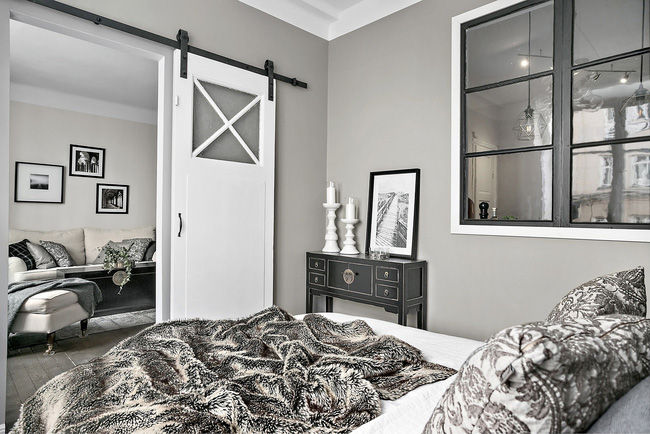Hình ảnh phòng ngủ màu trung tính hiện đại, kết nối với phòng khách qua cửa trượt màu trắng