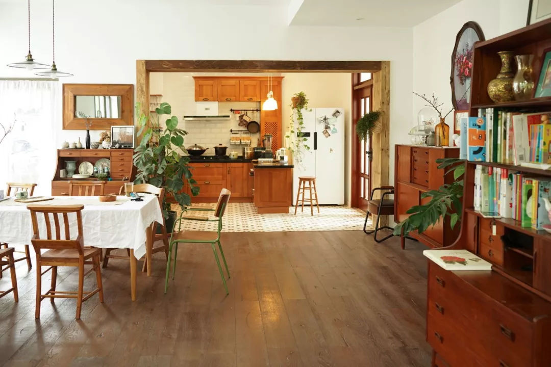 Hình ảnh toàn cảnh phòng ăn và khu vực bếp nấu thoáng sáng, sử dụng nội thất gỗ chủ đạo