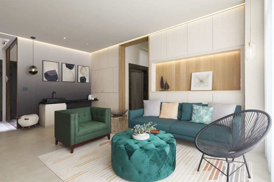 Phòng khách ấn tượng với sofa xanh lá, ghế thư giãn màu đen, tường ốp gỗ