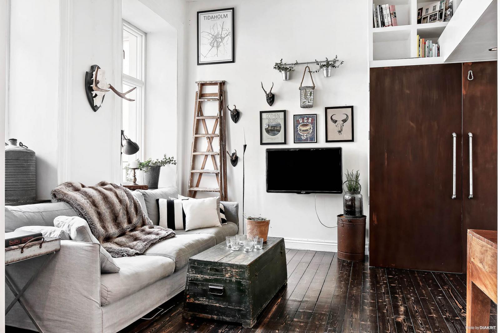 Một góc phòng khách với sofa xám, tranh treo tường, tivi, bàn trà độc đáo