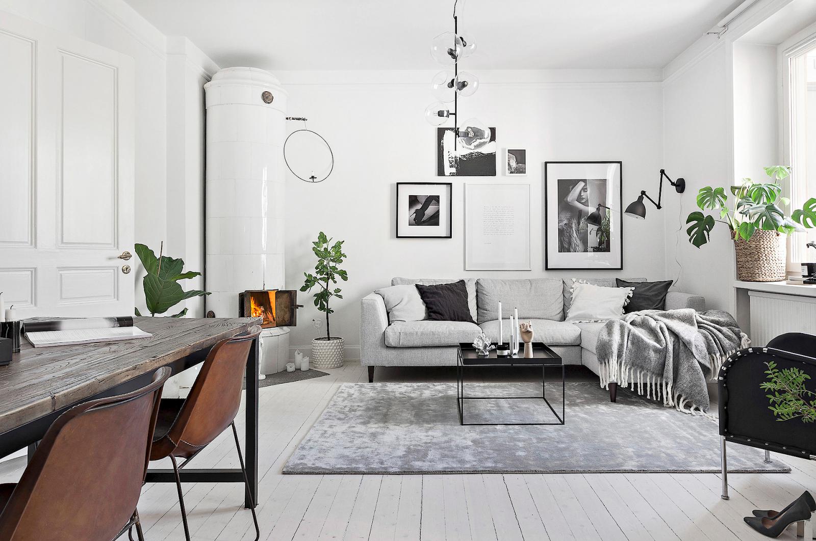 Hình ảnh phòng khách thoáng sáng với sofa xám trắng, tranh treo tường, cây xanh trang trí