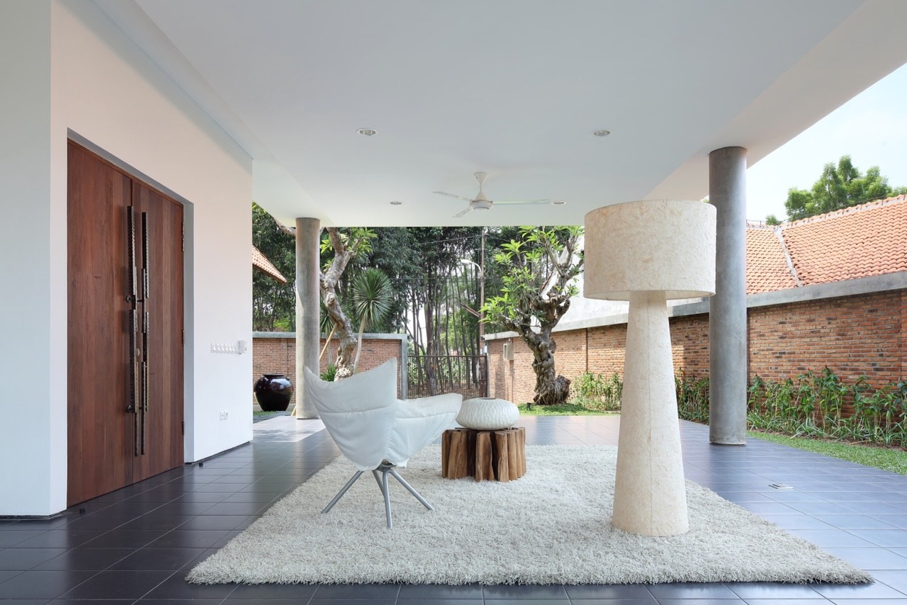Góc thư giãn nơi hiên nhà được bài trí khá ấn tượng với thảm trải lông màu trắng, ghế ngồi cùng tông, bàn trà từ gỗ nguyên khối.