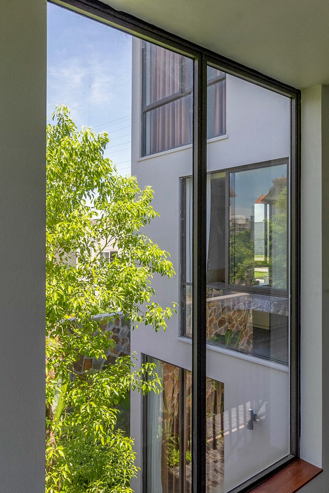 Hình ảnh cận cảnh những khung cửa sổ kính mở ra sân vườn, cây xanh tươi tốt