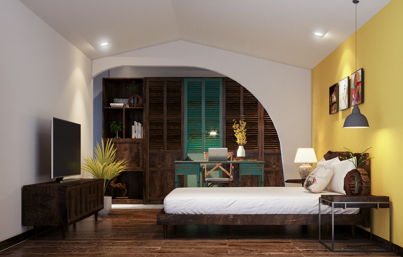 Hình ảnh phòng ngủ với tường đầu giường sơn vàng, đối diện là tủ kệ tivi bằng gỗ, tủ quần áo cùng tông, khung cửa vòm, bàn làm việc