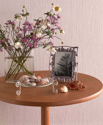 Lọ hoa nhỏ đặt trên bàn gỗ giản dị