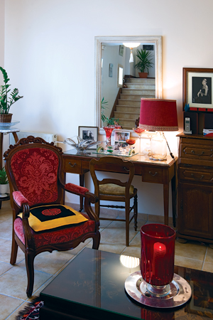 Một góc phòng khách, ghế mang phong cách Louis 14, bàn và tủ art decor làm bằng gỗ walnut đều là đồ thừa hưởng từ ông bà. Những tấm ảnh kỷ niệm gia đình tạo cảm giác đầm ấm. Không nặng về tiểu tiết, căn phòng có cảm giác nhẹ nhàng cùng cây xanh khắp nơi
