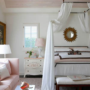 Chiếc giường sắt với các đồ vải lanh màu hồng, nâu và trắng.