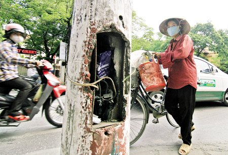 Dây điện lòng thòng ở cột đèn đường ngã tư Nguyễn Thái Học - Cao Bá Quát - Văn Miếu, Hà Nội. (Ảnh: Chí Cường)
