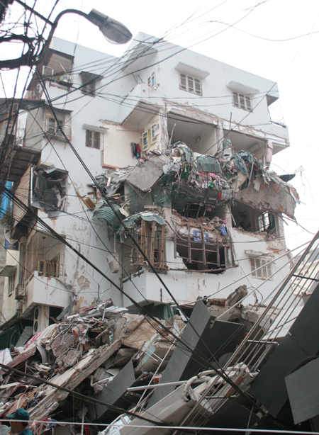Vào khoảng bốn giờ chiều nay (31/03), ngôi nhà 5 tầng tại số 49 đường Huỳnh Thúc Kháng đổ sập nghiêm trọng sang phía chung cư bên cạnh. (Ảnh: Duy Khánh)