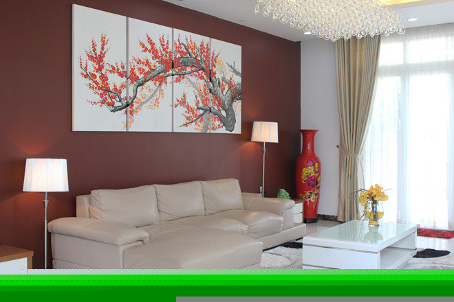 Mảng tường đỏ cùng bức tranh hoa đào là điểm nhấn cho không gian phòng khách đơn giản.