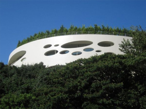 Căn nhà có cấu trúc hình tròn bao quanh một sân trong cũng được phủ một màu xanh ngút ngát của cây cỏ.