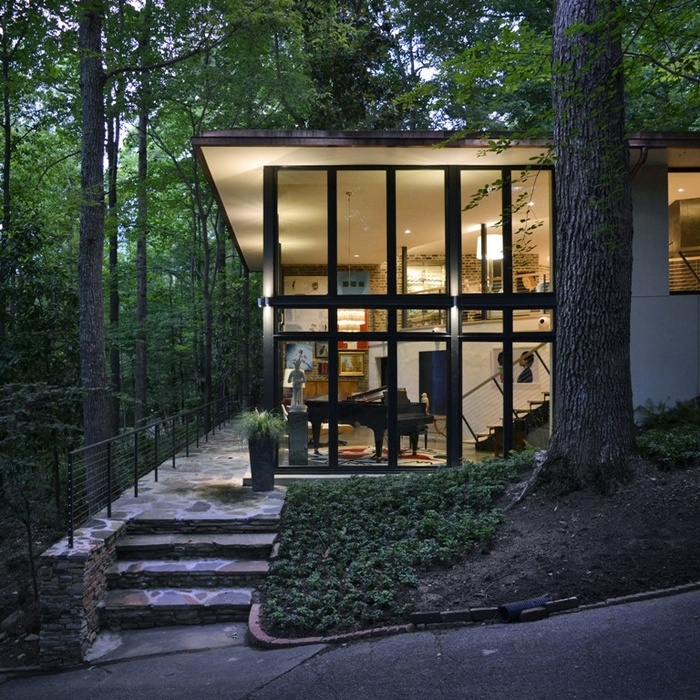 Tường kính giúp xóa nhòa khoảng cách giữa không gian bên trong nhà nghỉ dưỡng với cảnh quan núi rừng xanh mát.