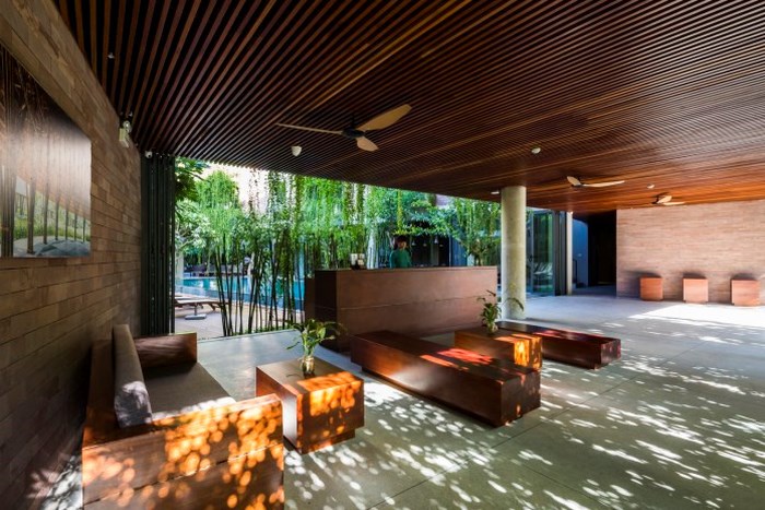 Trần của sảnh khách sạn xanh được ốp gỗ quý tạo cảm giác ấm áp và gần gũi với thiên nhiên.
