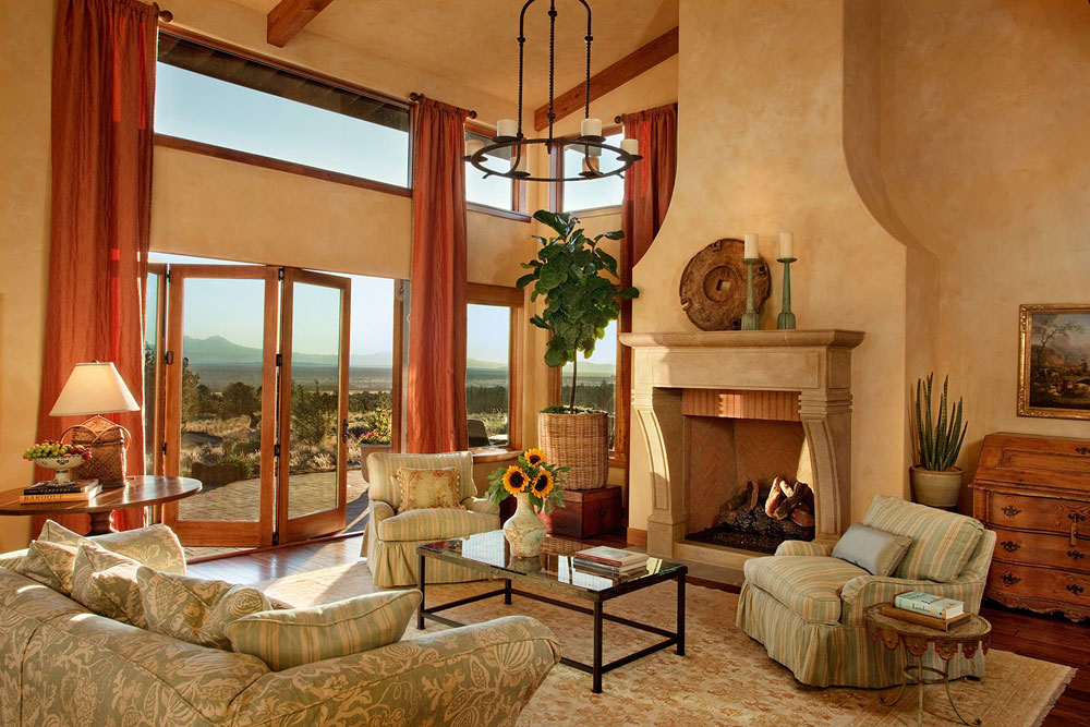 Hình ảnh phòng khách được bài trí theo phong cách nội thất Tuscan với bộ ghế sofa tông màu nhã nhặn đặt gọn gàng trên thảm trải sàn, lò sưởi ấm áp va những khung cửa kính cao rộng.