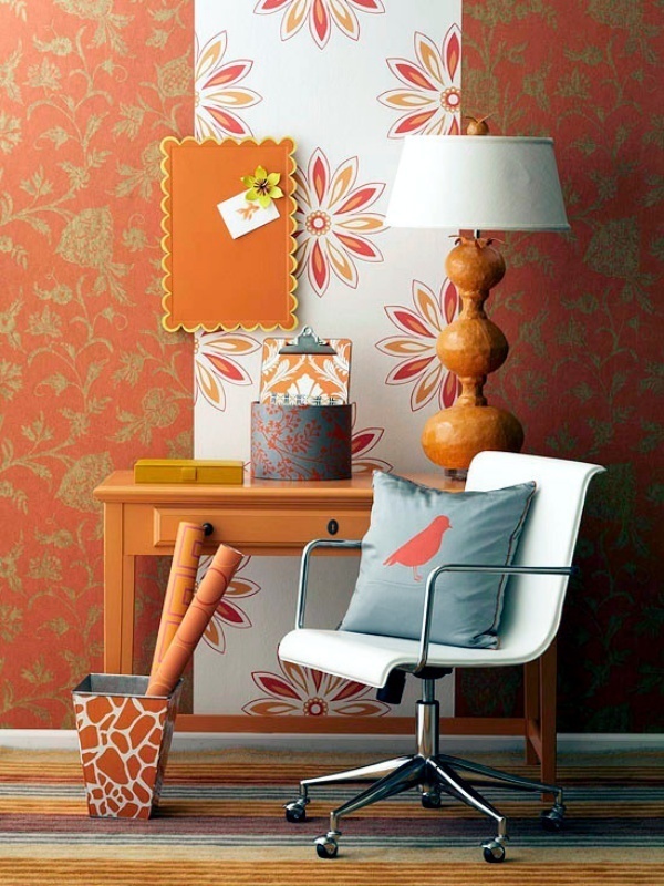 Hình ảnh góc nhà nhỏ được trang trí với giấy dán tường màu cam đất, kệ gỗ nhỏ xinh