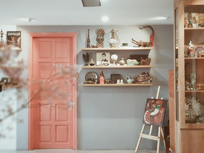 Hình ảnh ngay cạnh cửa phòng ngủ màu hồng san hô là kệ trưng bày đồ lưu niệm yêu thích.