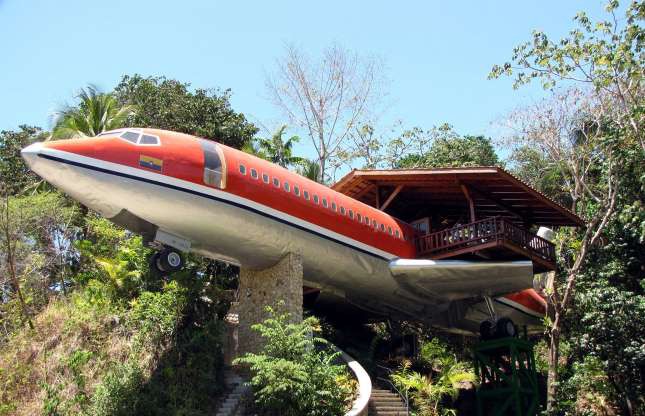 Hình ảnh cận cảnh máy bay Boeing 727 được cải tạo thành khách sạn, bao quanh là cây xanh vùng nhiệt đới