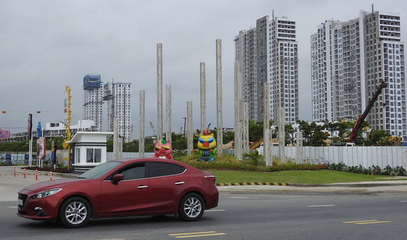 Hình ảnh những tòa nhà cao tầng đang trong quá trình hoàn thiện, xung quanh đường sá rộng rãi, ô tô đậu
