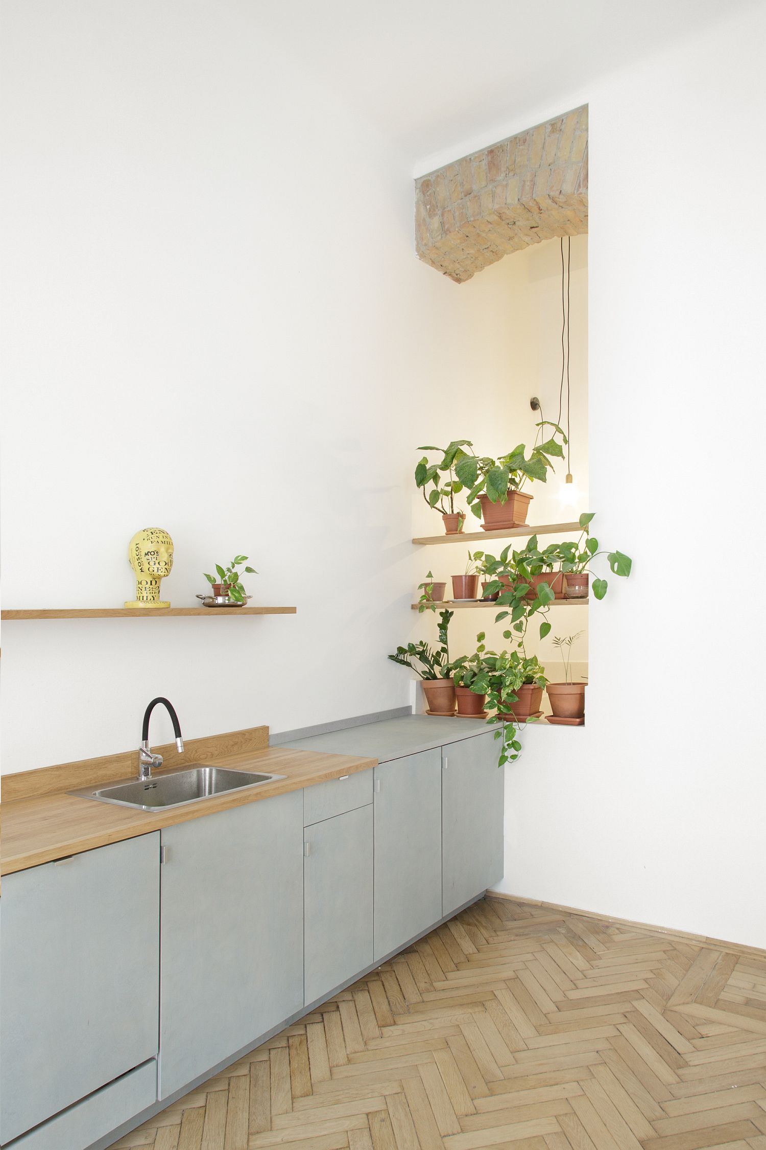 Hình ảnh mảng dầm gạch mộc không sơn trát kết hợp ăn ý cùng cây xanh, đèn trang trí tạo thành góc nhỏ ấn tượng trong phòng bếp.