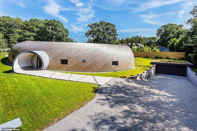 Hình ảnh ngôi nhà dáng vòm giống vỏ ốc độc đáo, tọa lạc giữa thảm cỏ xanh mướt, xung quanh có nhiều cây xanh