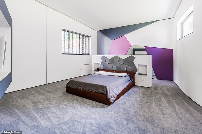 Hình ảnh phòng ngủ thoáng sáng với cửa kính hai bên, tường đầu giường trang trí ấn tượng với các mảng màu tím, họa tiết tổ ong